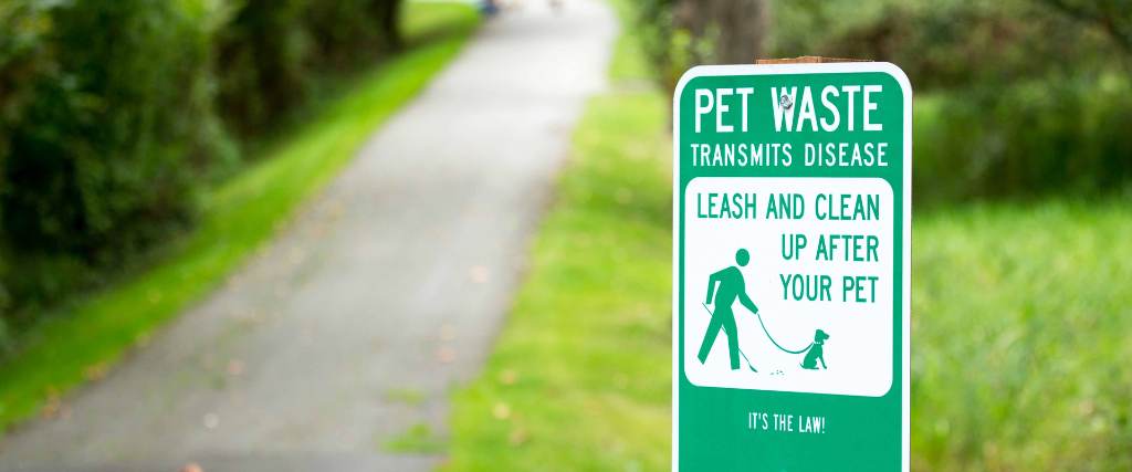 Pet waste sign asking people to clean up after pets