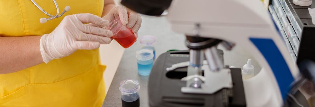 Veterinary technician performing ear cytology on dog.